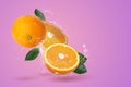 Creative layout made from Fresh Sliced Ã¢â¬â¹Ã¢â¬â¹oranges and Orange fruit  and water Splashing on a pink background Royalty Free Stock Photo